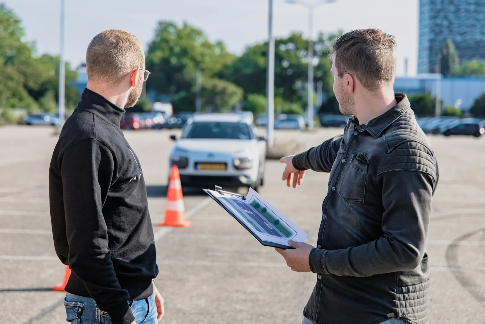 A driving examiner with a clipboard in the passenger seat