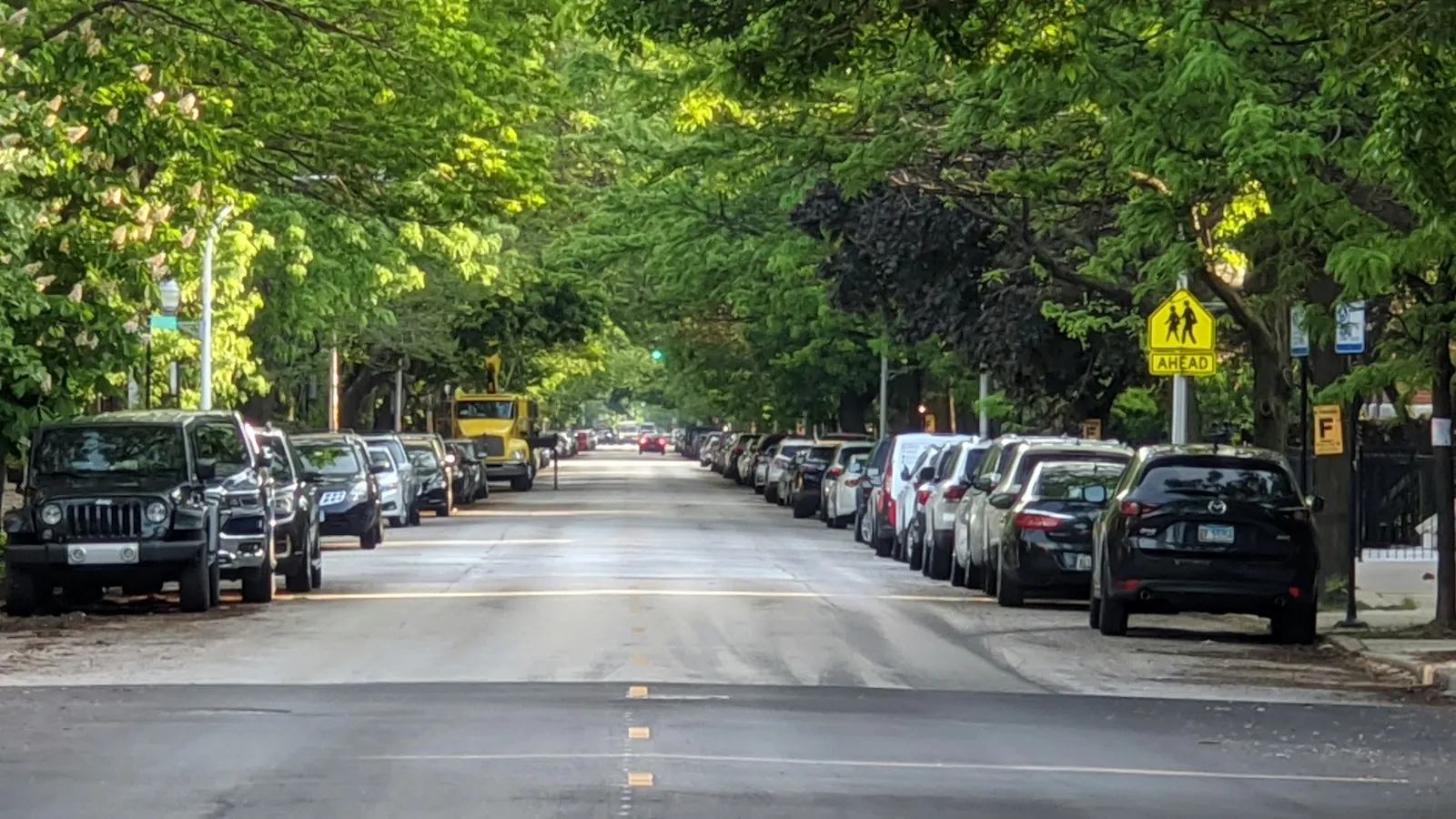 A car parallel parking between two parked cars